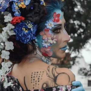 A woman with vibrant face paint and floral headdress in vibrant festival attire, Mexico City.